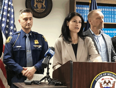  Michigan Attorney General Dana Nessel, center — flanked by, at left, Michigan State Police Lt. Steve Temelko, and at right, Oakland County Executive Dave Coulter — gives a press conference Dec. 11 in Detroit to announce arrests in two crime sprees across the state. 