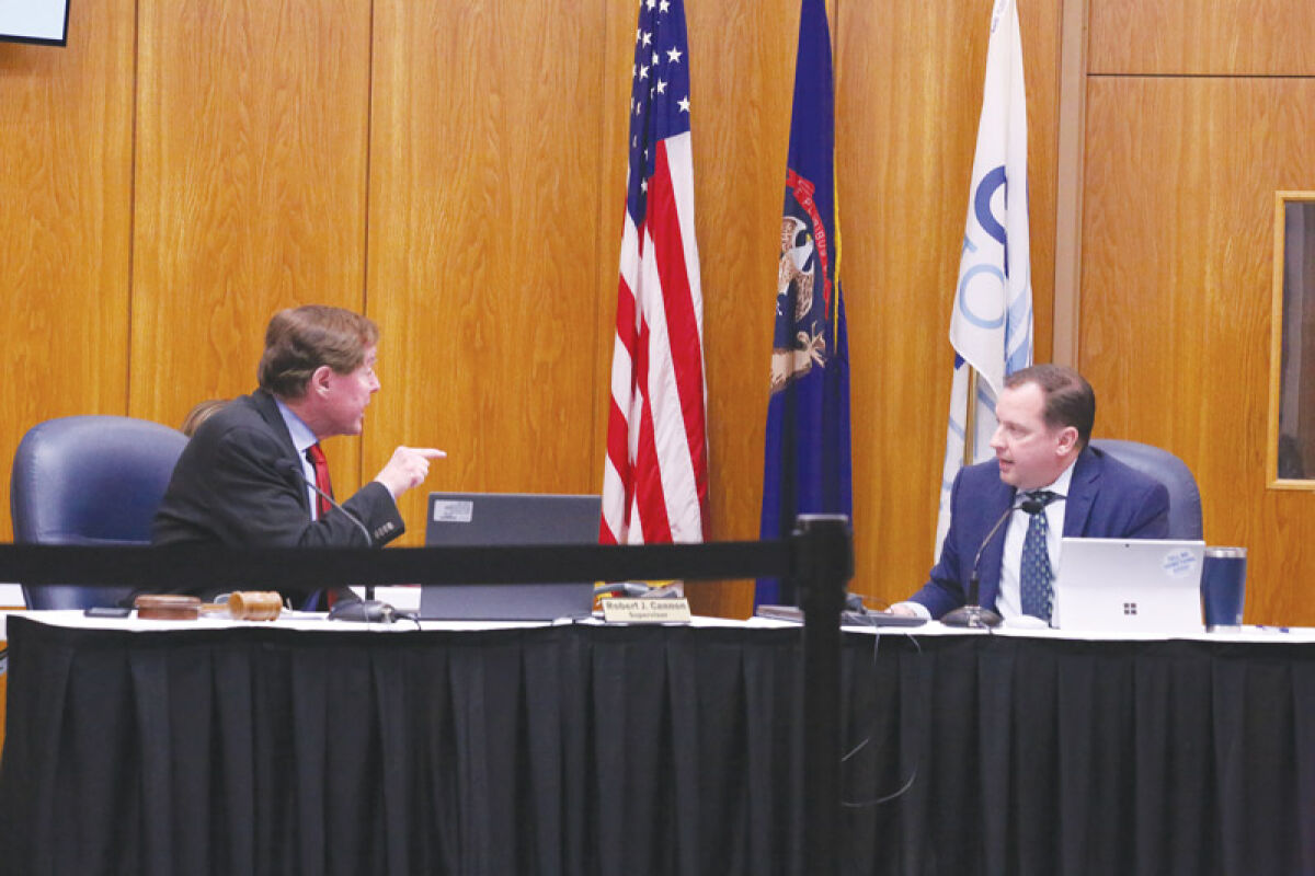  Clinton Township Supervisor Robert Cannon, left, argues with Clinton Township Treasurer Paul Gieleghem about Gieleghem’s opposition to an early voting mailer. Cannon threatened to have Gieleghem removed from the meeting by Police Chief Dina Caringi, though this did not come to pass. 