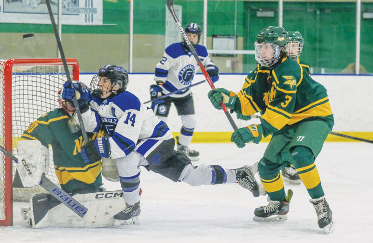  Farmington United junior forward Curtis Kent falls into the Grosse Pointe North defender during a matchup between the two schools Dec. 20 at Farmington Hills Ice Arena. 