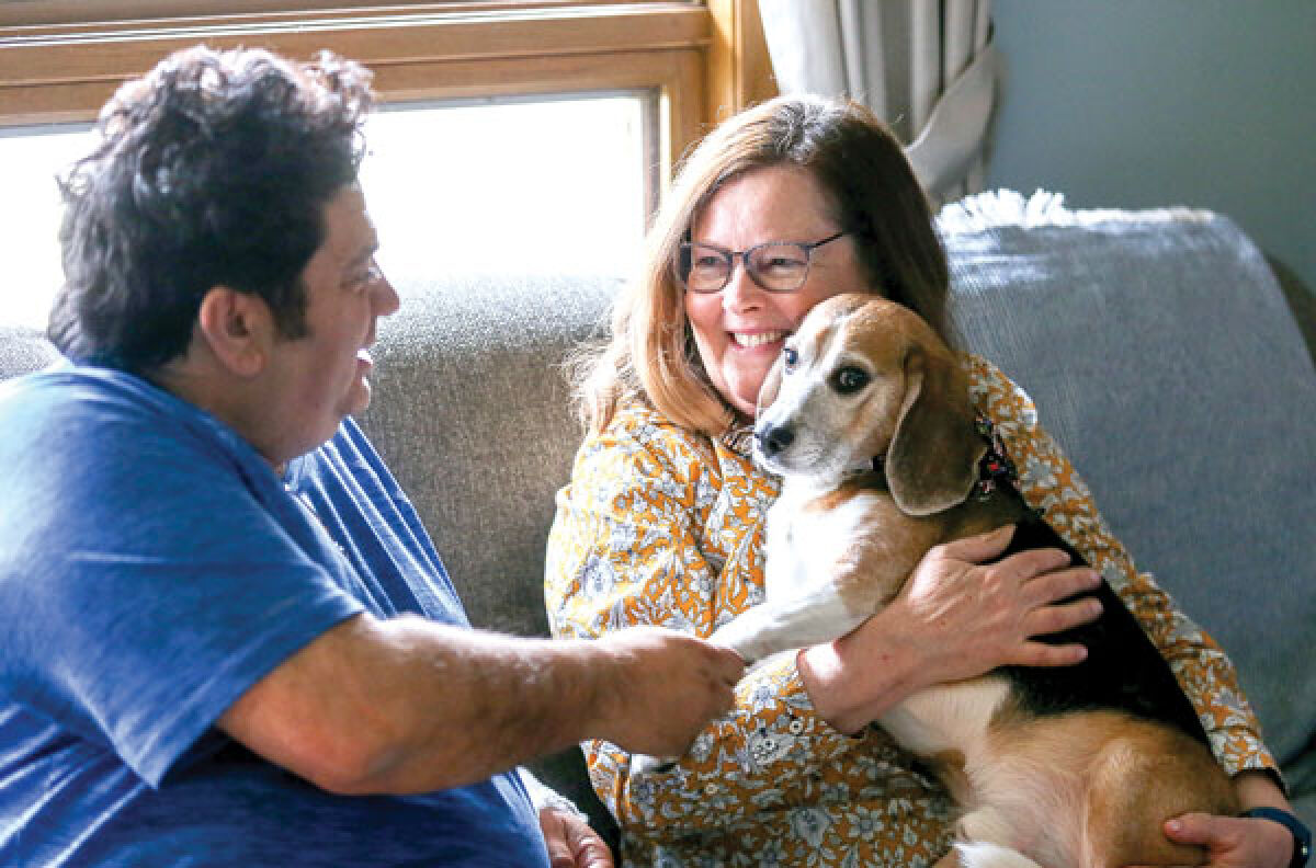  Dave Rubello, a St. Clair Shores city councilman and C & G Newspapers employee, and his wife, Greta Guest Rubello, hold Teddy. The couple adopted Teddy in 2019. 