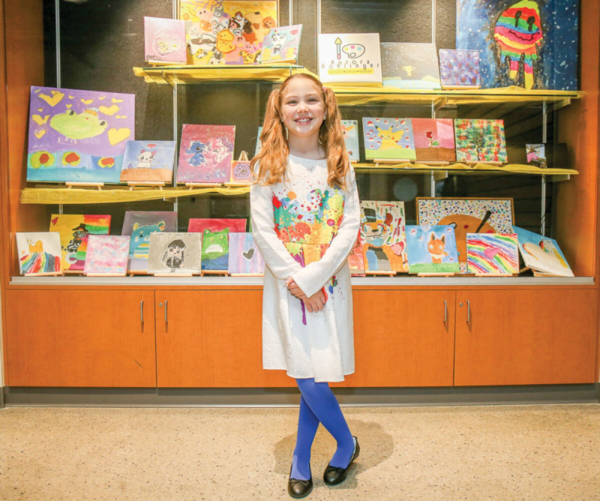   Aurora Bohlinger, 8, displays her paintings at the Sterling Heights Community Center. She was the Sterling Heights Featured Artist for December 2023. 