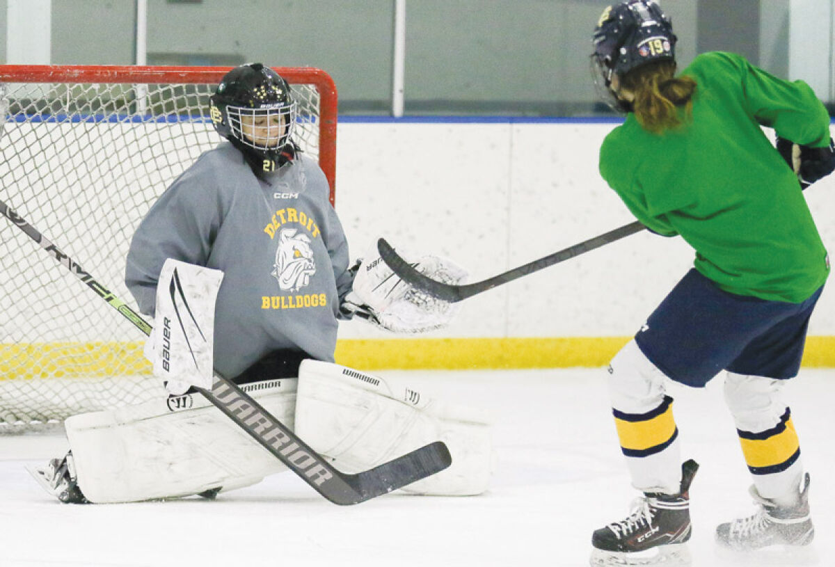   Grosse Pointe South senior Maeve Hix, right, fires a shot at junior goalie Rosie Smith, left, during a team practice Jan. 3  at East Side Hockey Ice Arena.  