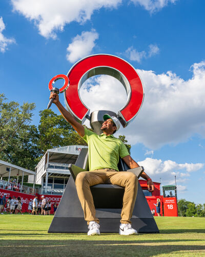  Rocket Mortgage Classic champion Tony Finau lifts up the trophy on the RMC throne July 31 in Detroit. 