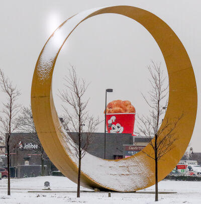  A decorative bucket of Jollibee chicken appears through the Halo sculpture along M-59 Hall Road Jan. 11. Sterling Heights officials cite the presence of new restaurants like Jollibee as the fulfillment of their vision for a “Golden Corridor” along Hall Road. 