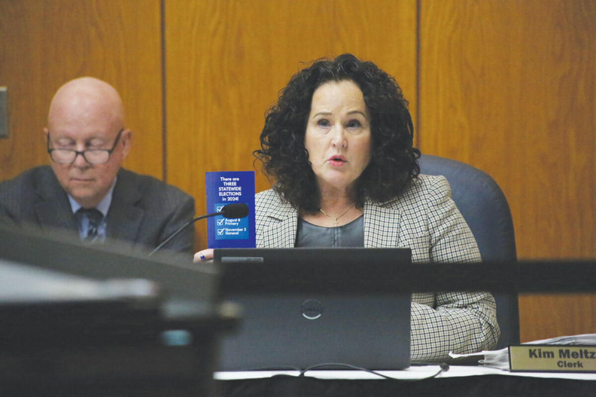  Clinton Township Clerk Kim Meltzer holds up an early voting informational mailer at the Jan. 8 meeting. The mailer was the  subject of spirited debate for  two consecutive meetings. 