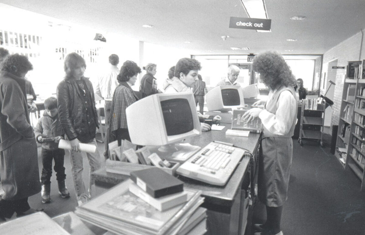  Patrons line up to check items out at the library in 1986. 
