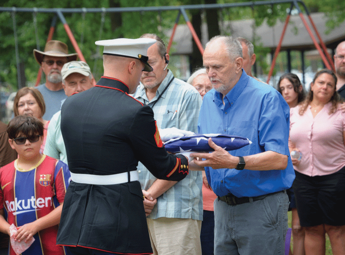  Marine Sgt. Keith Pouliot presents the flag to McDermott’s brother, Bill Brown. 