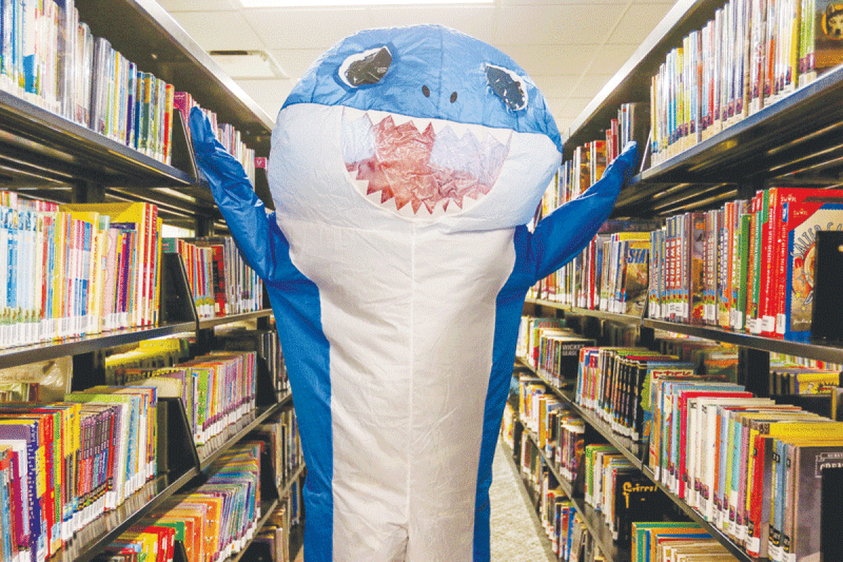  A shark mascot helps the Sterling Heights Public Library usher in its summer reading program, “Oceans of Possibilities.” 