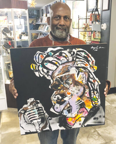   Artist Angelo Sherman holds his mixed media painting, “James Brown.”  