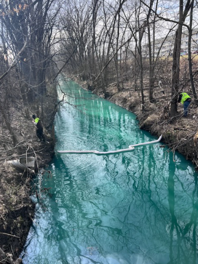  Workers stretch a containment boom over the Bear Creek in Warren.  