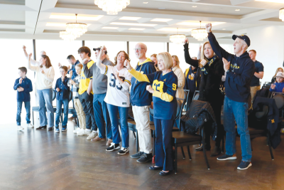  The audience at The War Memorial sings the Michigan fight song,  “The Victors.” 