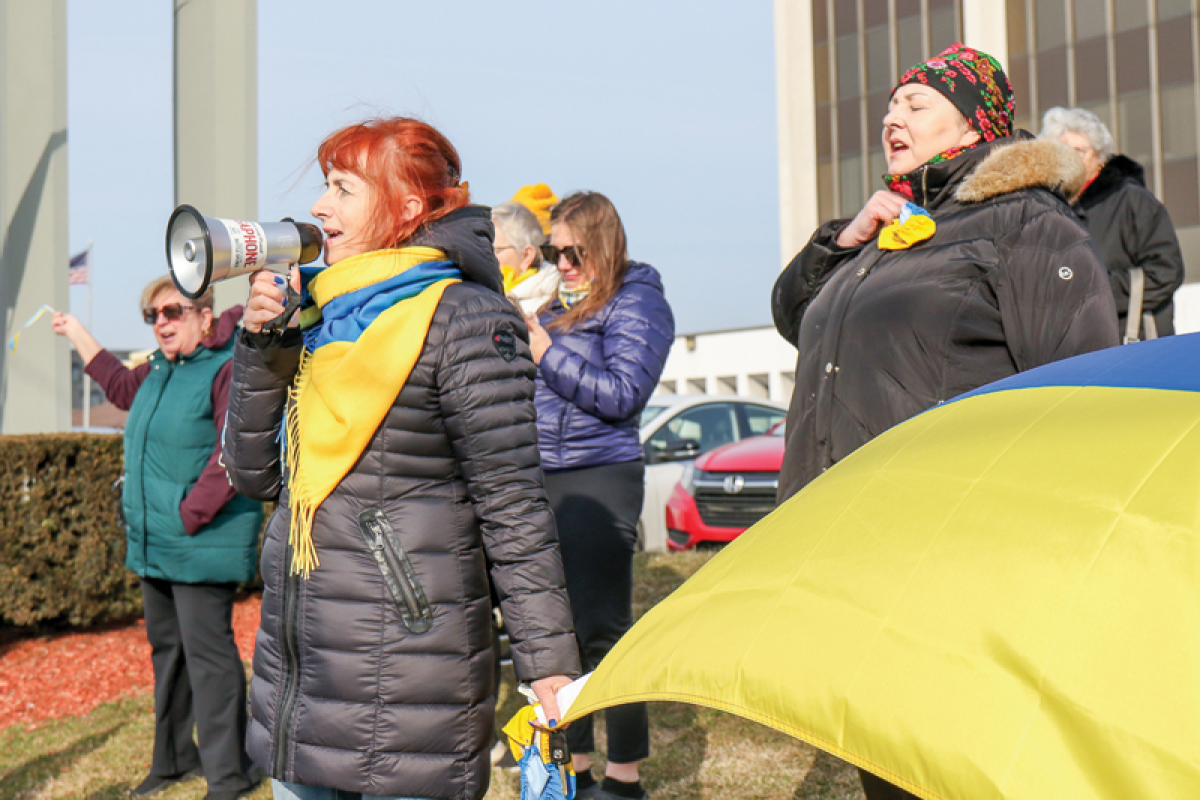  Olga Bronetska, of Madison Heights, leads chants and songs through a megaphone during a demonstration Feb. 26 outside of the Warren office of U.S. Rep. John James. 