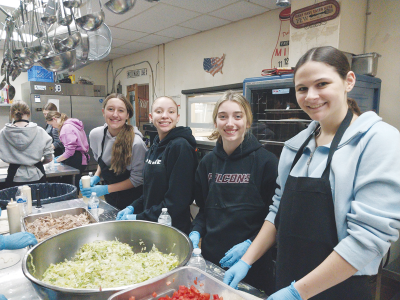  Violet Anderegg, Tyra Wright, Lilah Earl and  Clarie O’Brien prepare ingredients as part of the meal to be served at Grace Centers of Hope Feb. 9. 