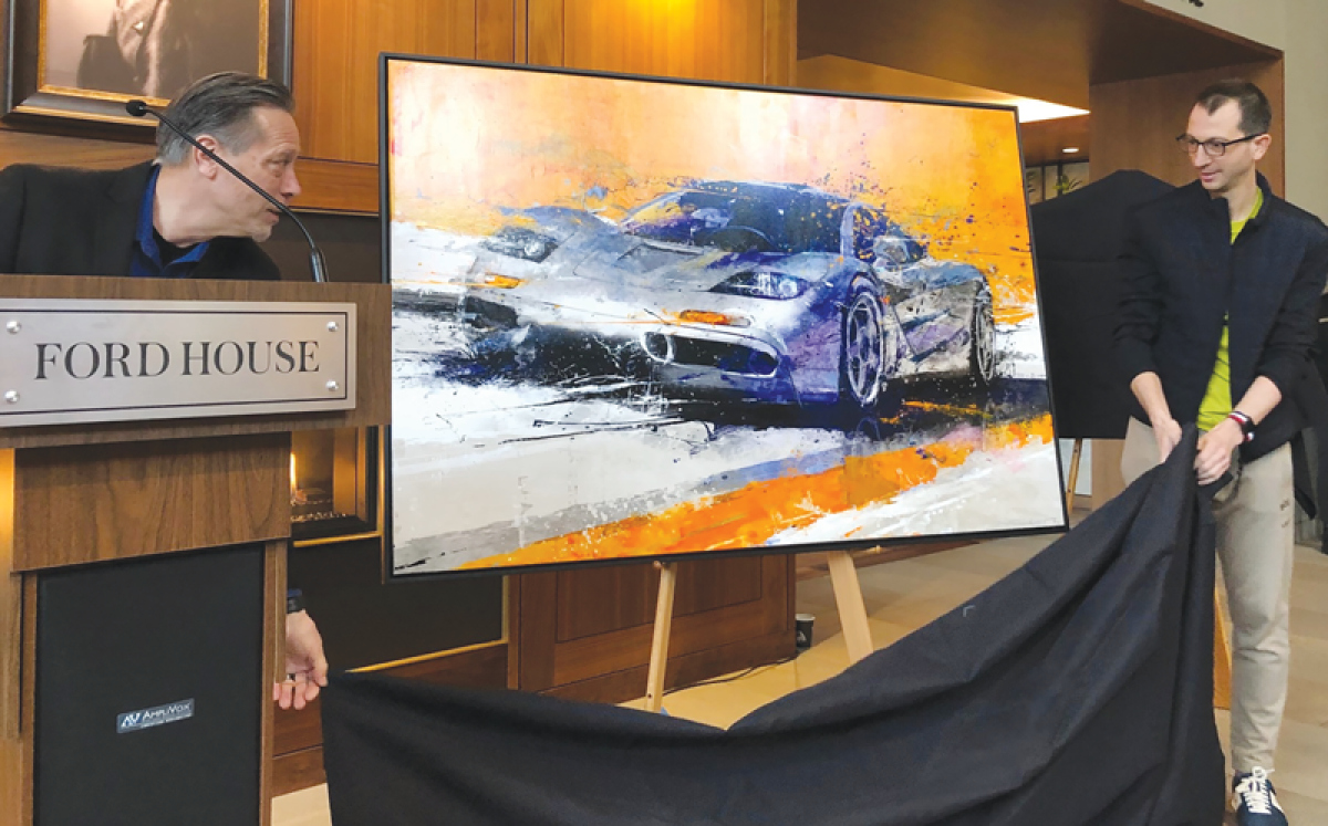  From left, EyesOn Design Chief Judge Glen Durmisevich and artist Nicolas Rousselet unveil Rousselet’s painting of the McLaren F1, which is being used for the 2024 EyesOn Design poster. 