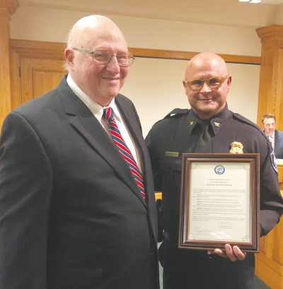  Longtime Grosse Pointe Park veterinarian Dr. Lawrence Herzog is presented with a proclamation from the city by Public Safety Director James Bostock. 