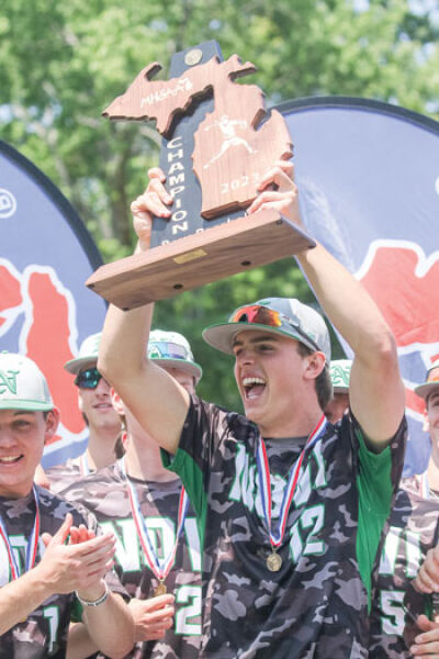  Novi graduate Andrew Abler raises the state championship trophy after winning the MHSAA Division 1 state title June 17 at McLane Stadium at Michigan State University. 