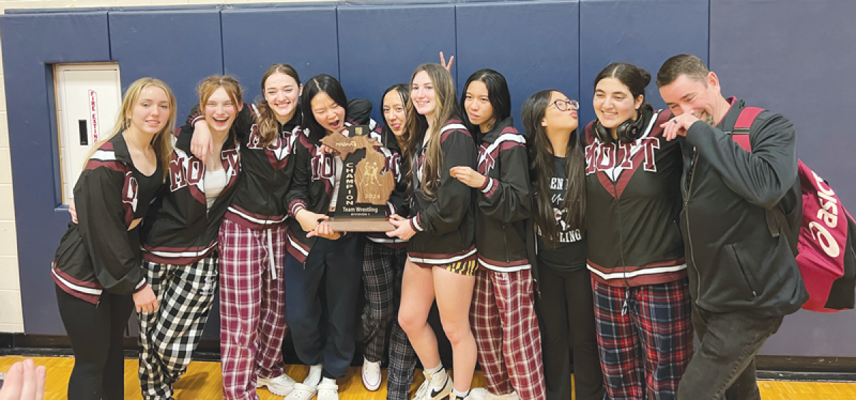  Warren Mott’s female wrestlers celebrate the wrestling team’s regional championship  on Feb. 14 at Fraser High School.  