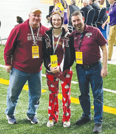  Warren Mott girls head coach Paul Salyers, left, and  coach Jeff Pruitt, right, stand with Warren Mott junior Megan Melnyk, who placed eighth at the  MHSAA state finals on March 2 at Ford Field. 