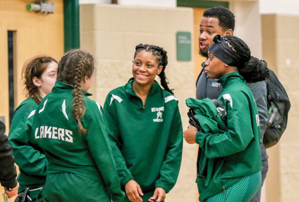  Members of the West Bloomfield girls wrestling team have a conversation before the Birmingham Groves Tri-County girls wrestling meet Jan. 7 at Groves High School. 