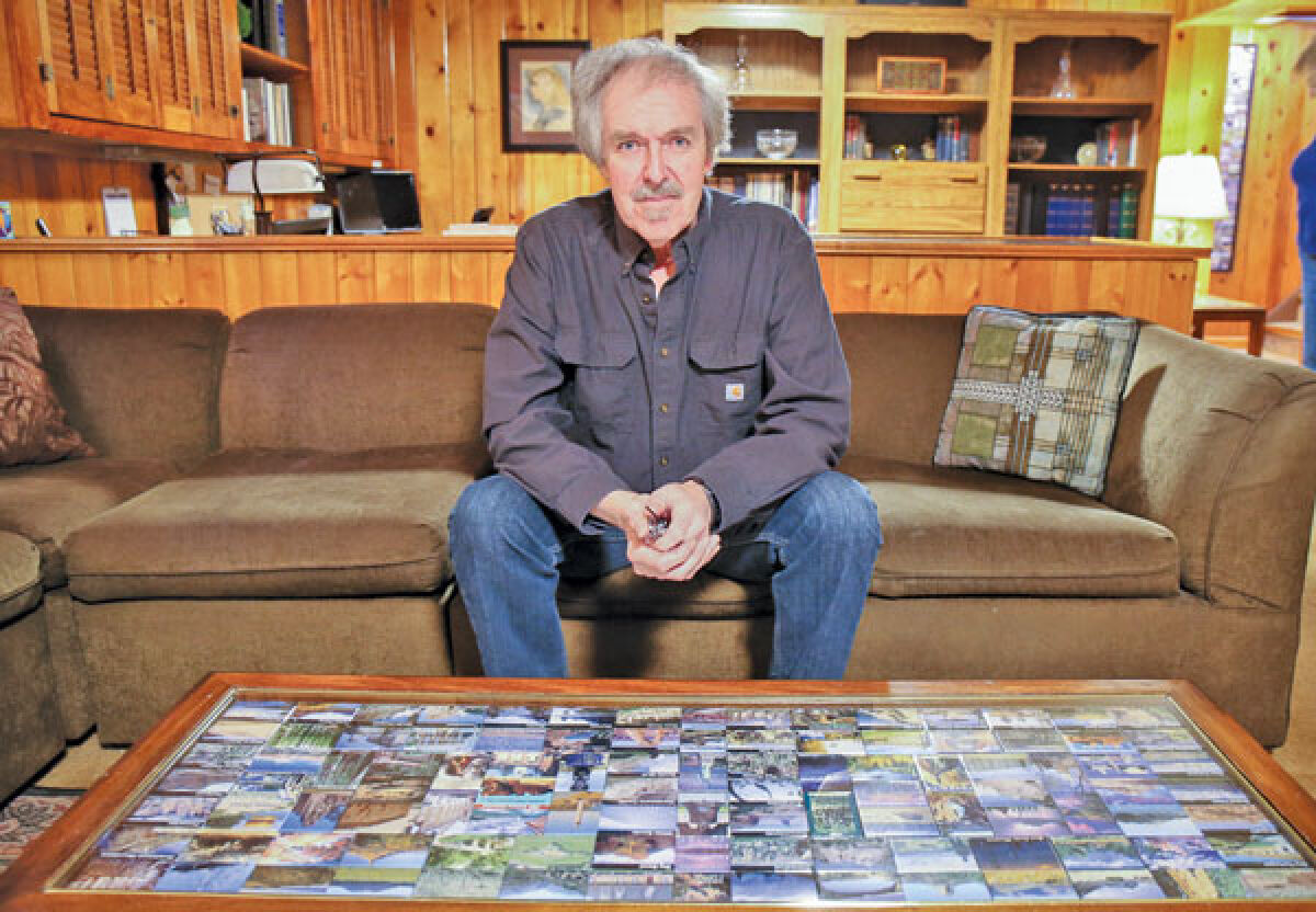  Ed Stanczak sits near a table filled with all the magnets from his travels. 