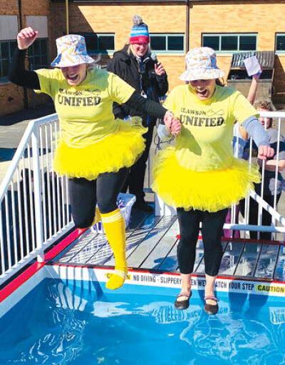  Clawson Public Schools staff members Amy Hatto, left, and Amanda Schwark, right, dressed up as the “Frozen Fries,” jump into the 45-degree water. 