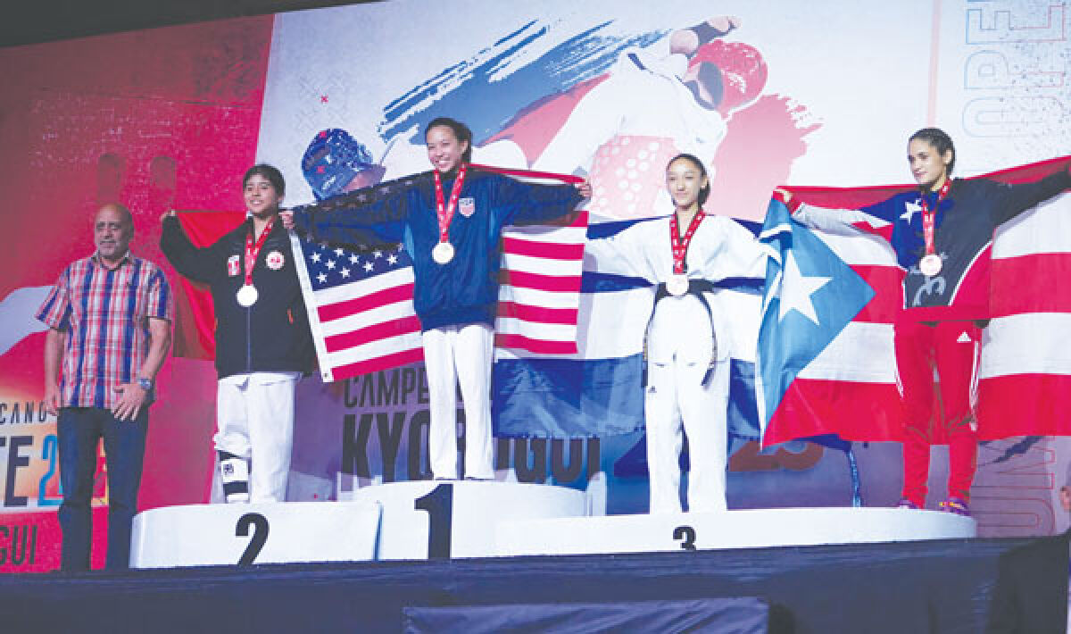  Halo Canezo of Troy stands atop the podium at the Dominican Open Taekwondo competition after receiving her gold medal at the event. 