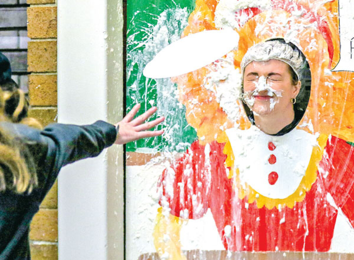  Novi High School math teacher Jamie Allcorn takes a pie in the face as part of the school’s Wish Week activities March 14. 
