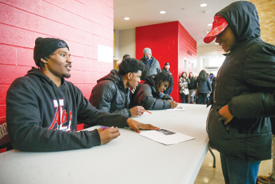  Warren Lincoln senior TJ Minor signs an autograph for a young fan. 