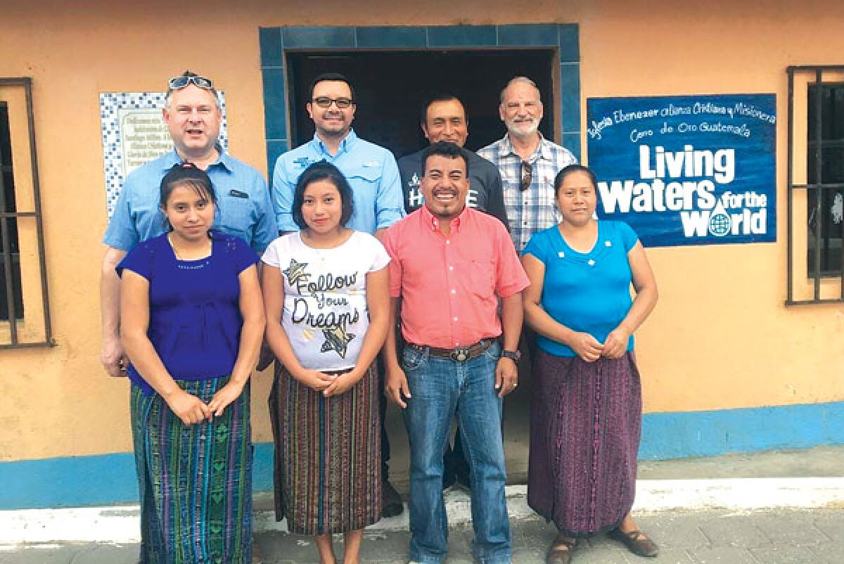  Missionaries Mark Turner, back row, right; and David VanZoest, back row, left, of Faith Community Presbyterian Church in Novi, pose with some of the people they are helping to obtain purified water in Guatemala. 