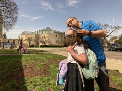  Shrine Catholic Grade School physical education teacher Gabe Flores holds protective glasses for student Kate Bates, 11, in Royal Oak. 