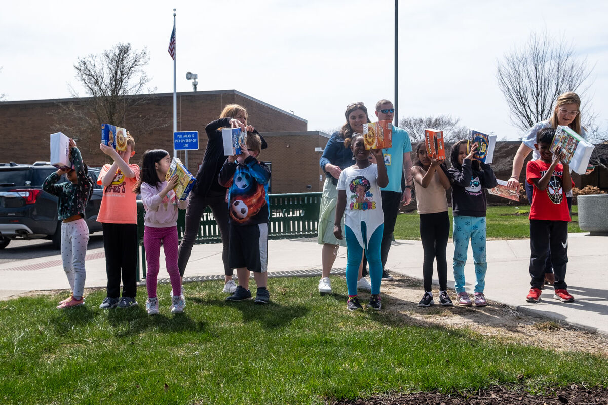  Village Oaks Elementary staff help a group of first graders use pinhole viewers to safely watch the solar eclipse Monday, April 8, 2024, in Novi. 