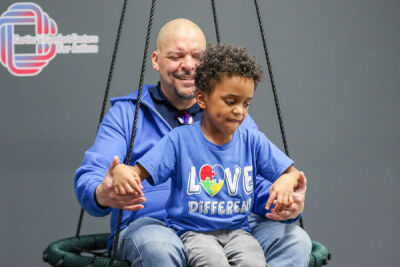  Cartier Carter, 7, enjoys a ride on the swing with his dad, Jeffrey Carter. 