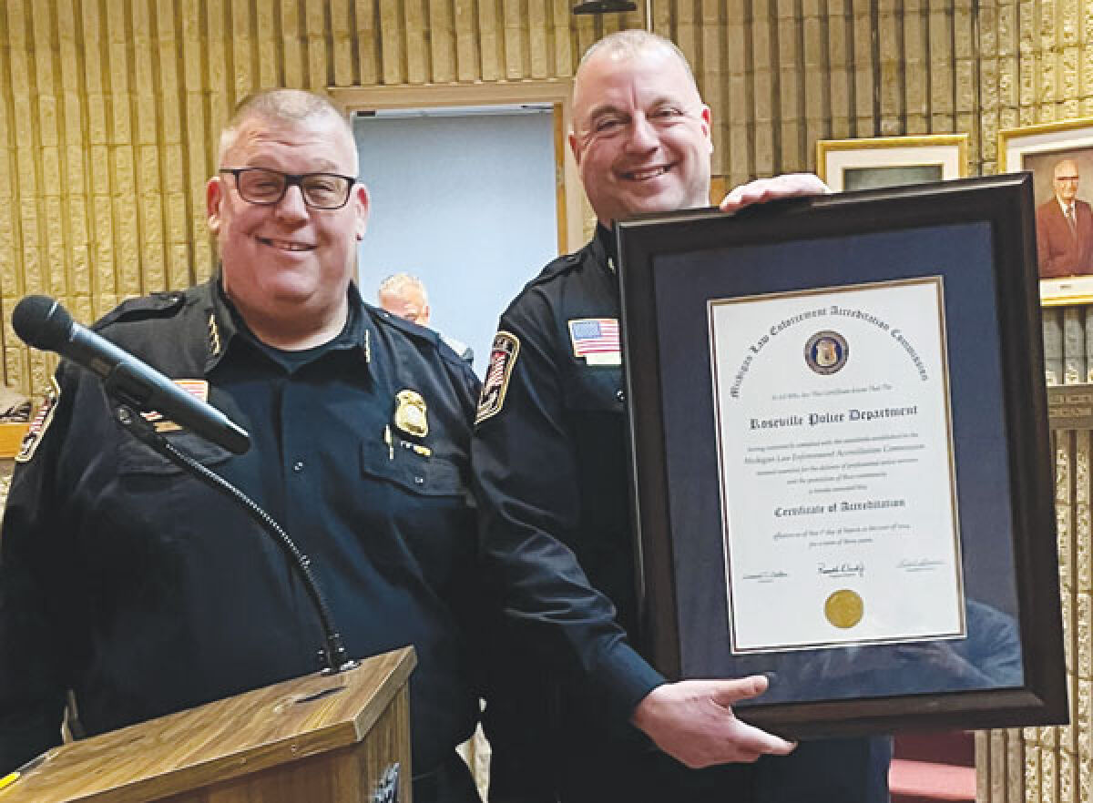  Roseville Police Chief Mitch Berlin, left, and Deputy Chief Robert Gudenau pose with the department’s recent re-accreditation from the Michigan Association of Chiefs of Police. The two gave a presentation at the Roseville City Council’s April 9 meeting. 