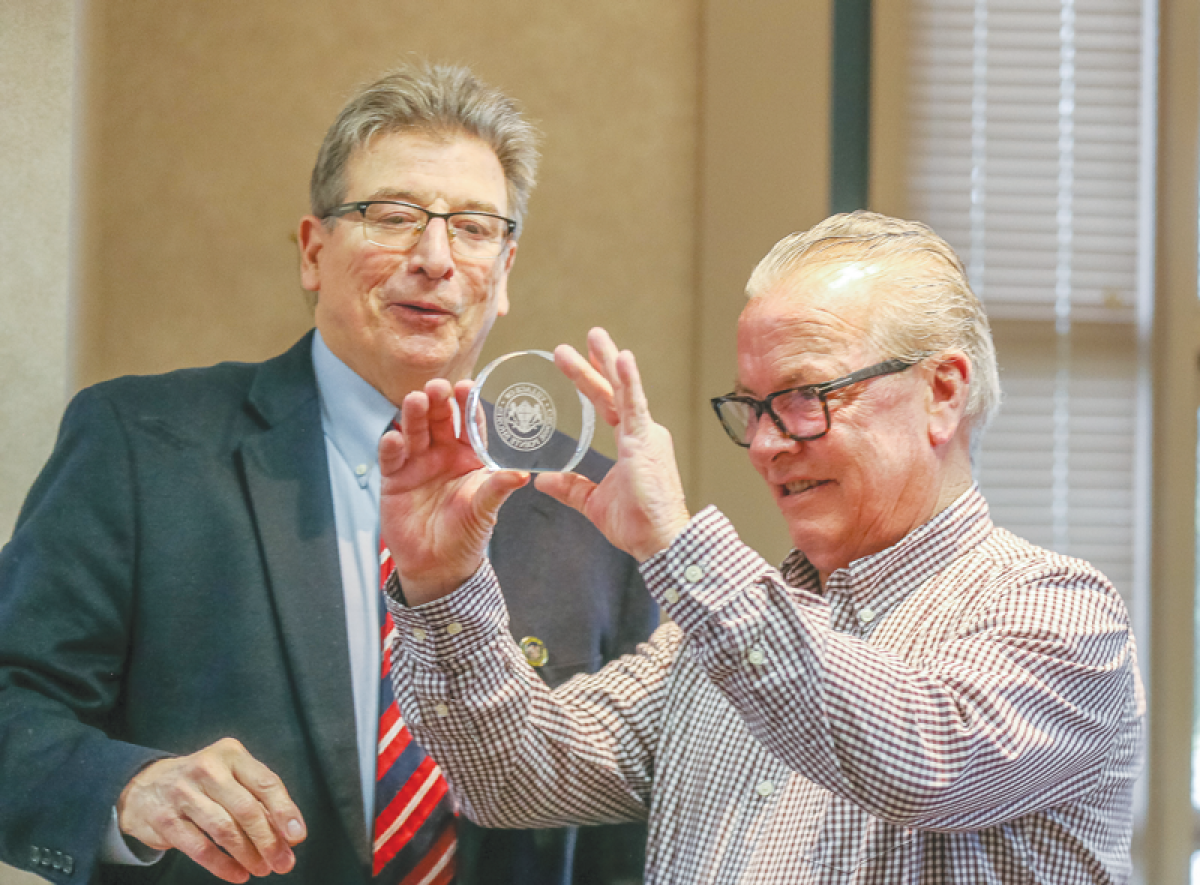  Retiring Grosse Pointe Shores Assistant City Manager Tom Krolczyk, right, admires a crystal embellished with the city’s emblem that was presented to him during his retirement party March 27 by Mayor Ted Kedzierski, left. 