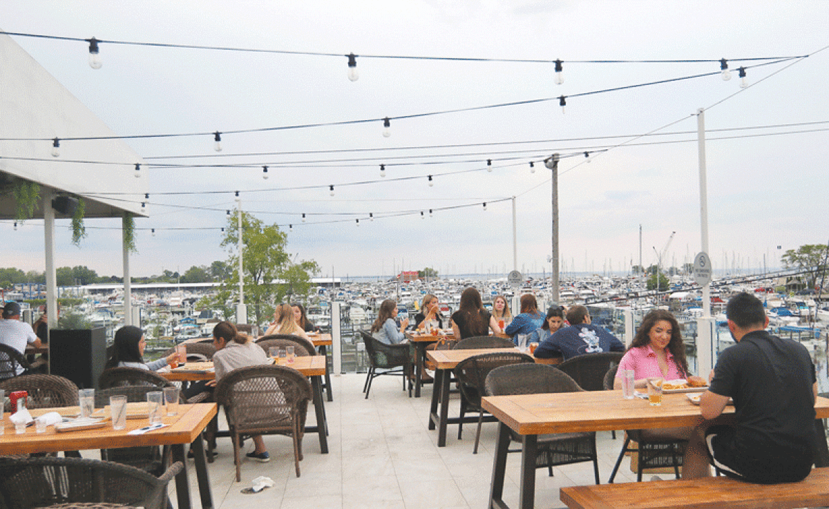  Patrons enjoy the patio at Zef’s Dockside, with an elevated view of the water. 