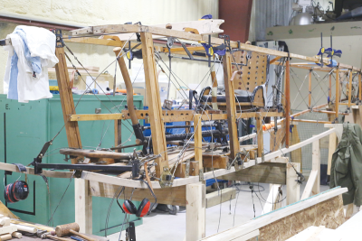  Lacking its cloth skin, the fuselage of the Curtiss JN-4 Jenny reveals its wood beam and metal cable innards. The plane’s prior owner was able to bring the 110-year-old plane into airworthiness before it was broken during a hard landing in 2023. 