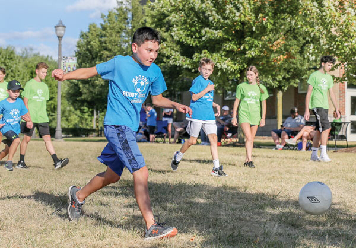  Evan Szepytowski, 12, of Macomb Township, scores a goal at a Buddy Soccer session as players and buddies watch on. 