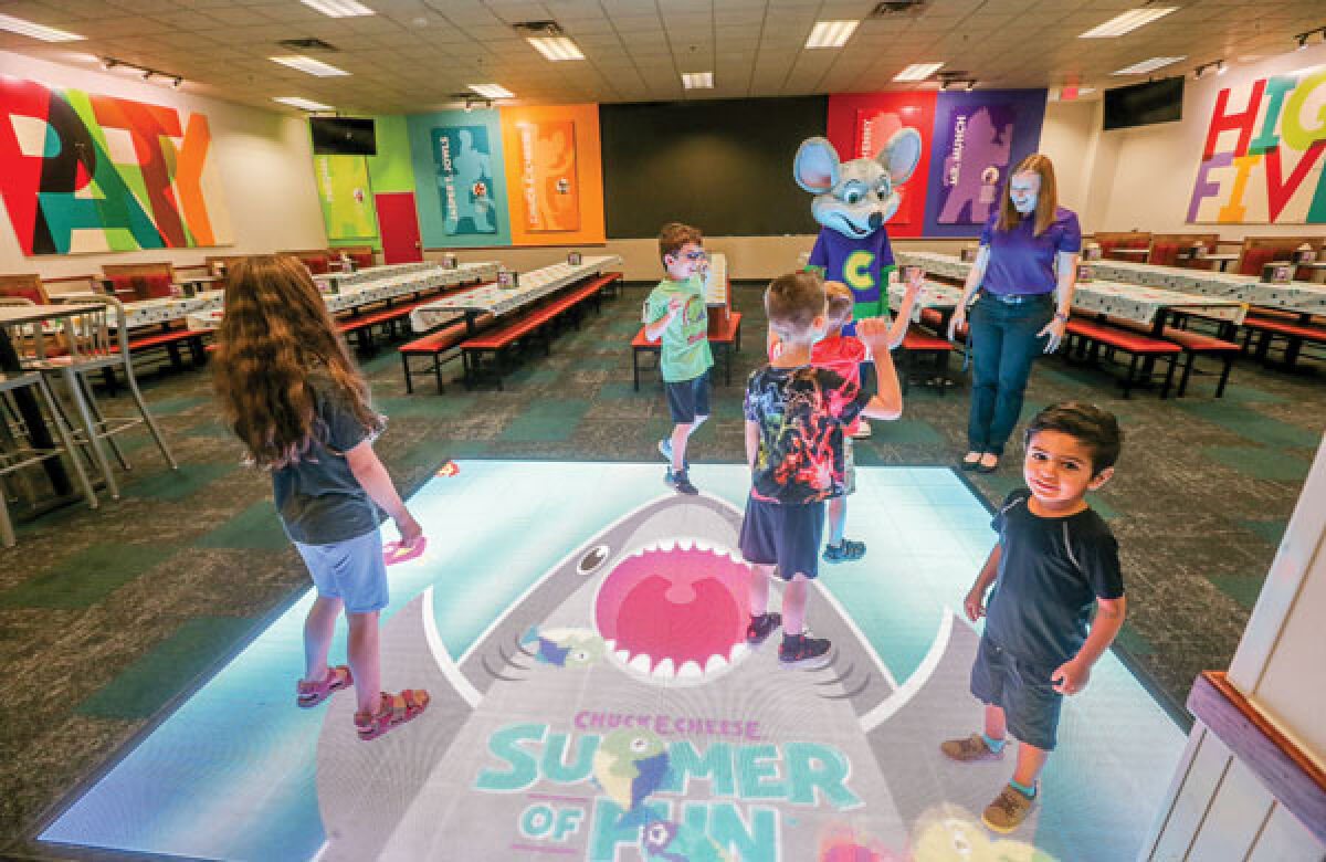  Kids dance on the video floor with Chuck E. Cheese himself during the first-to-play event at Chuck E. Cheese Novi July 28. 