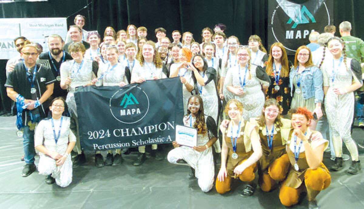  The Dakota High School drumline poses with medals and a victory banner after winning the Michigan Alliance for the Performing Arts Percussion Scholastic A Championship at Eastern Michigan University on April 14. It is the program’s second MAPA championship after winning last year’s title. 