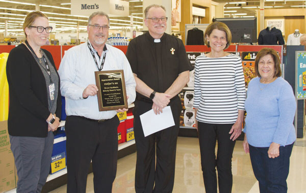  Meijer Store Director Bruce VanMaele holds up a plaque from St. Paul of Tarsus Church Food Pantry for donations the Hall Road store made. To the left of him is Meijer human resources representative Melody Read. Marc Rybinski, deacon at St. Paul of Tarsus, is in the center with Florence Hogan, far right, and food pantry coordinator Joyce Yaklin. 