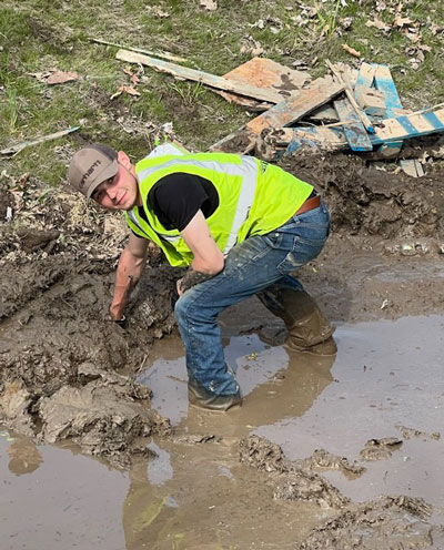  Logan McClure works to clear debris from the scene. 