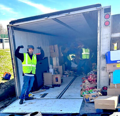  Aaron Essley, a worker from Hadley’s towing, flexes his muscles as he finishes unloading the semi. 
