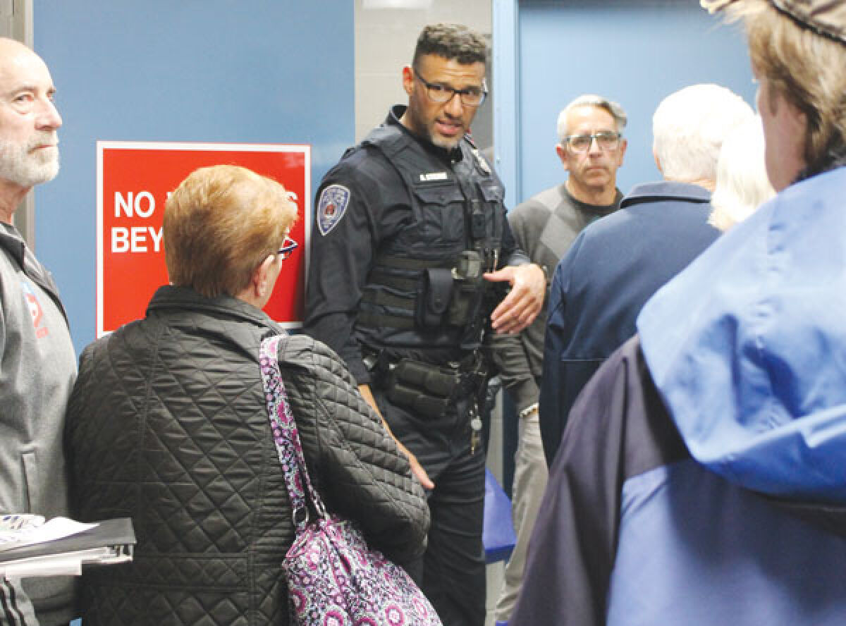  Royal Oak police officer André Stienke shows the April 24 Justice Open House attendees what the inside of the Police Department’s holding cell area looks like. 