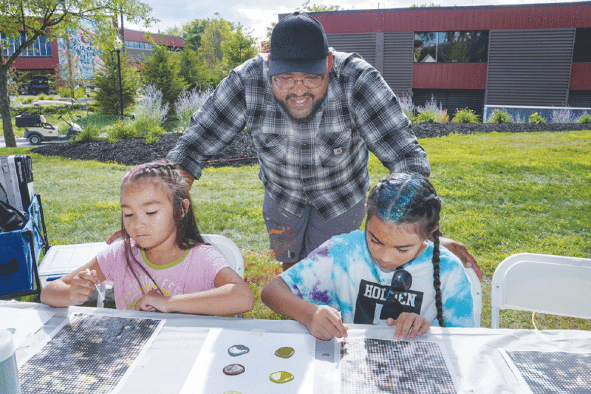  Artist Doug Jones helps sisters Aria and Serafina Pegoraro, of Sterling Heights, get started on their paintings for his PIXEL community art project at Sterlingfest. The completed piece will hang in the lobby of Henry Ford Macomb Hospital’s new north tower lobby when it opens in spring 2023.  