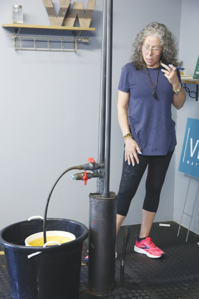  Lois Lombardo, owner of the Olympia Salon & Spa and the Park Well, discusses the well’s operation over the phone with Lisa Saylor, who worked with the well’s prior owner.  