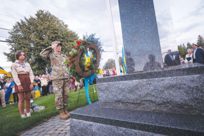  U.S. Air Force Technical Sgt. Tanya Clark, who is half-Ukrainian, salutes after placing a wreath at the foot of a monument. 