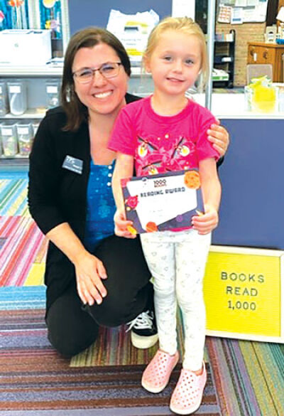  Troy Public Library Head of Youth Services Keegan Sulecki stands with local reader Vaida Thompson after Thompson completed the library’s Read 1,000 Books Before Kindergarten Challenge. 