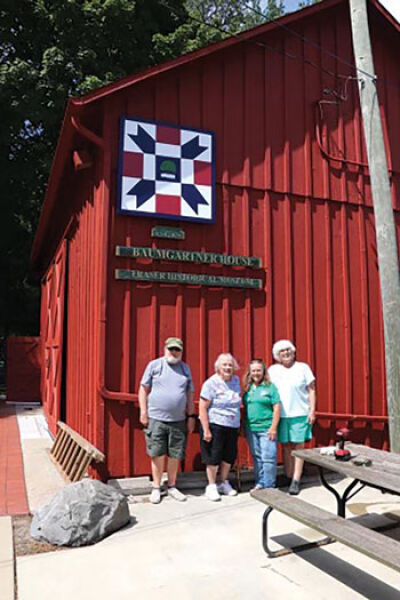  James Chamberlain, Marilynn Wright, Vania Apps and Sue Bertolini-Fox, pictured left to right, stand beneath the new barn quilt added to the historic barn at the Baumgartner House Museum. 