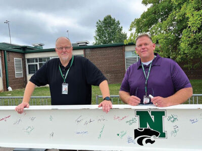  Eric Hettel, assistant director of maintenance, left, and Mike Dragoo, the director of maintenance, pose with the beam, which they signed. 