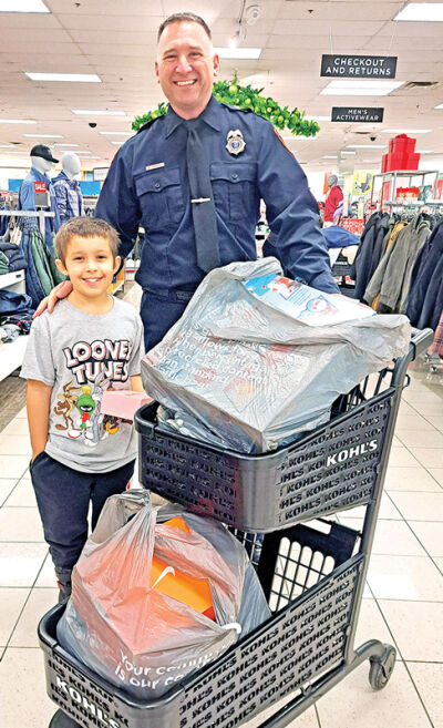Gio Clavenna, 9, and Novi firefighter Matt Osborne enjoy shopping together.